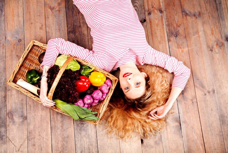 Chica con una cesta de verduras.